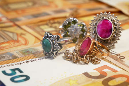 money and jewelry, pawn shop and buy and sell golden rings, necklace bracelet o wooden background, closeupの写真素材