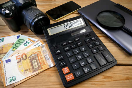 laptop, calculator, digital camera and money, store selling photographic equipment, pawnshop concept, closeupの写真素材