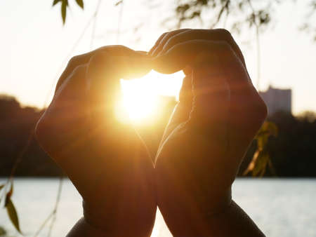 Sunset In Heart Hands near river and forest, outdoorsの写真素材