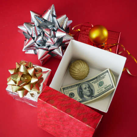 big gift box with ribbon bow and stack of money, merry chirtmas and happy new year concept