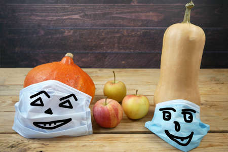 pumpkin wearing a face mask for protection from coronavirus. Halloween and covid-19 pandemic conceptの写真素材
