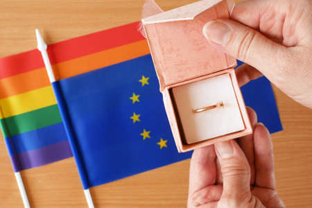 gold wedding ring on rainbow lgbt flag and European Union flag. Homosexual marriage. Same-sex marriage is allowed in european countries Concept. Closeupの写真素材