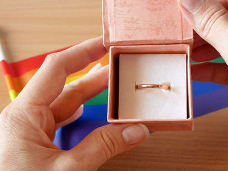 gold wedding ring on rainbow lgbt flag and European Union flag. Homosexual marriage. Same-sex marriage is allowed in european countries Concept. Closeupの写真素材