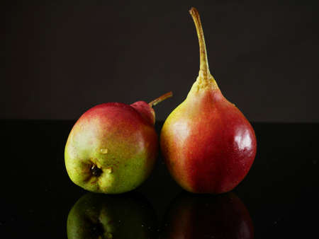 Juicy red ripe pears fruits on black background, closeupの写真素材