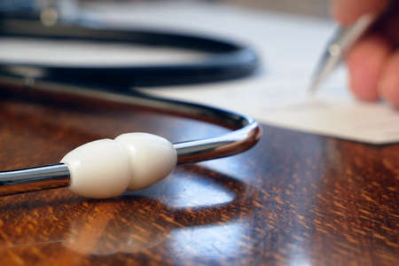 stethoscope and insurance contract on wooden table. Concept of expensive treatment, medical insurance conceptの写真素材