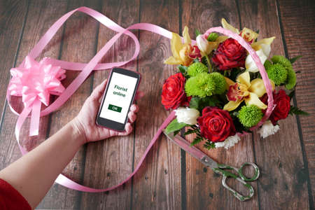 Business owner in flower shop, florist online with big flowers bunch, workplace florist, top view