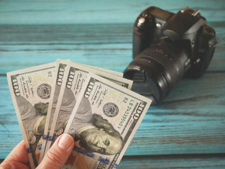 digital camera and money, store selling or rent photographic equipment, pawnshop concept, closeupの写真素材