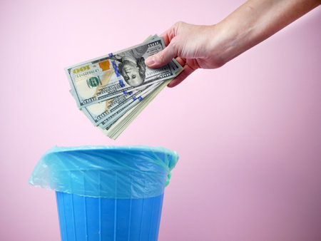 hand gettting out cash money in trash container, Concept of global garbage recycling and recession, inflationの写真素材