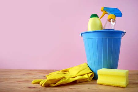 plastic bucket with brushes, gloves and detergents in the kitchen, basket with cleaning items, closeupの写真素材