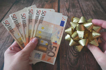 Money Gift, Money and bow on wooden background, closeup