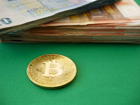 Golden bitcoin on Euro money background. Bitcoin cryptocurrency. Crypto currency. Bitcoins on euro banknotes pile. Top view. Closeupの写真素材