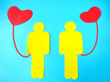 two people symbols holding red heart as balloons. Family insurance concept. World heart day, World health day. Love and Valentine's dating conceptの写真素材