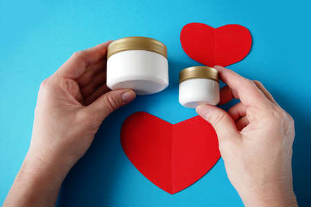 two bootles of cream cosmetic and red paper heart symbols, sales cosmetic for valentine dating...