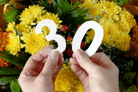 number 30 thirty anniversary from white letters on big bunch with beautiful yellow chrysanthemums...