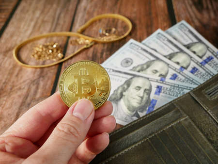 many golden and silver jewelry, bitcoin and cash money in wallet on black bakground, pawnshop...