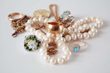 many golden and silver jewelry, pearls on white bakground, pawnshop concept, jewelry shop concept, closeupの写真素材