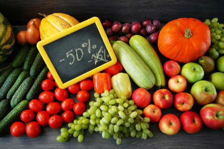 many different fruits and vegetables and nameplate with inscription sale, green glocery shop, healthy fresh colored fruits and vegetables background delivery concept, top viewの写真素材