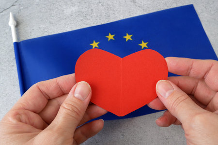 Flag of Europe with red heart symbol, european union flag on gray background, Europe Day 5th and 9th of May, Schumann Declaration day, I love Europe conceptの写真素材