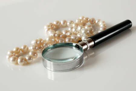 pearls necklace and magnifying glass on white background, jewerly inspect and verify, pawnshop concept, jewerly shop conceptの写真素材