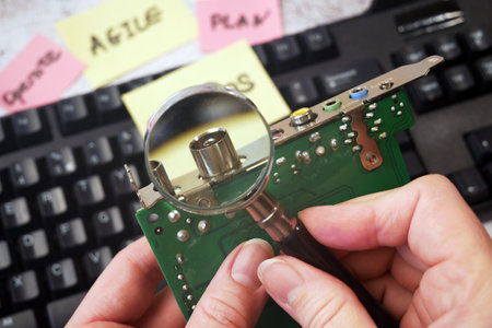 hands motherboard and keyboard near stickers about DevOps. DevOps Concept for software engineering culture and practice of software development and operation, closeupの写真素材