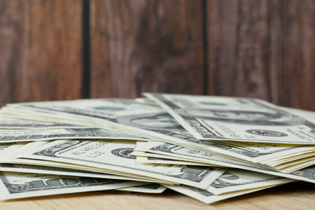 stack of usa dollars on wooden background with copy space, closeup