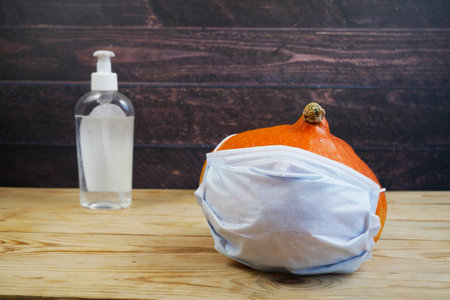 pumpkins, face medical masks for protection from coronavirus, sanitizer. Halloween 2022 concept. halloween party conceptの写真素材