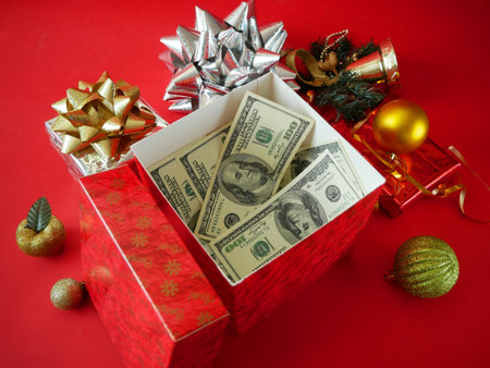 Merry Christmas and Happy New Year concept. pile of gift boxes and stack of money on red background. Big lot gift box decorative object. Holiday banner, web poster, flyer, greeting card. Xmas background, close upの写真素材