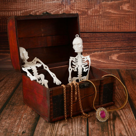 halloween composition with skeletons in a treasure chest and pumpkins as Jack O Lantern on wooden background. still lifeの写真素材