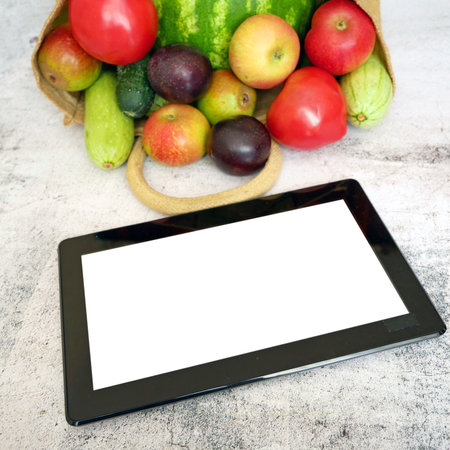 Organic Vegetables and fruits in cotton bag and tablet pc, online market, green grocery delivery at home concept, buy online conceptの写真素材