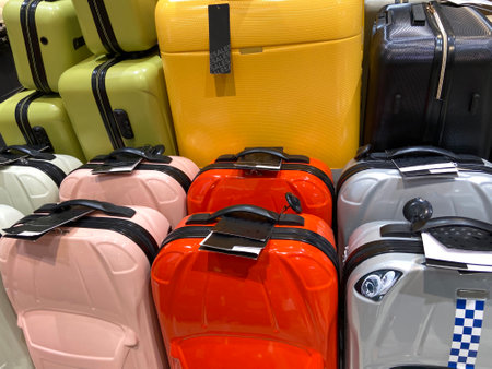 many different colorful modern suitcases, Set of suitcases with price tags in shop, pile of new travel suitcases luggages stacked, backgroundの写真素材