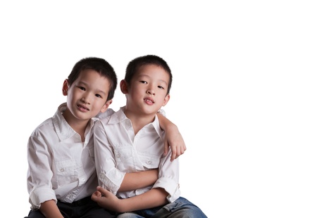 Two Young Asian Brothers wearing white shirts on an Isolated white background の写真素材