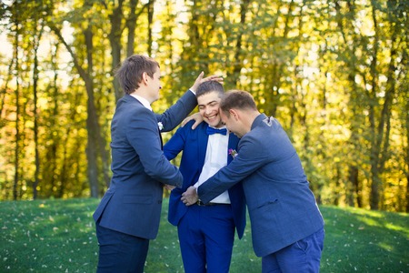 Friends laugh at the wedding of a friendの写真素材