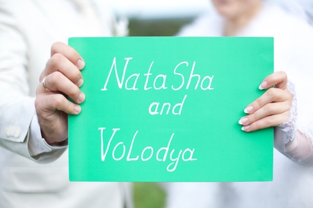 Hands newlyweds, wedding plaque inscribed with namesの写真素材