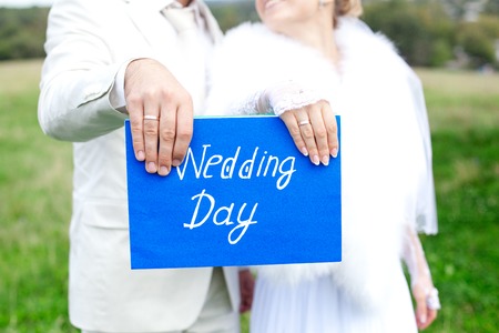 Hands newlyweds, wedding plaque inscribed with namesの写真素材