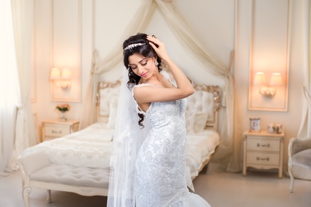 beautiful brunette bride in a luxurious wedding dress posing in interiorの写真素材