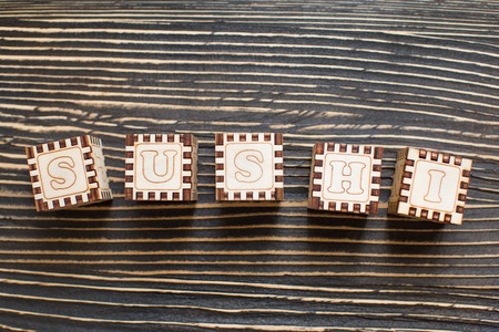 Wooden blocks with the English alphabet, sushi.