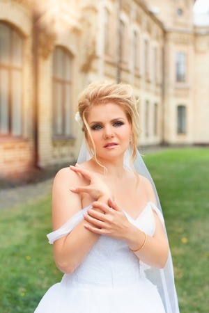 Stylish bride in a white wedding dress in summer dayの写真素材