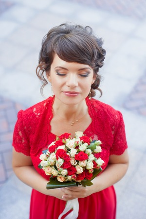 Girl in evening red dress in a warm summer dayの写真素材