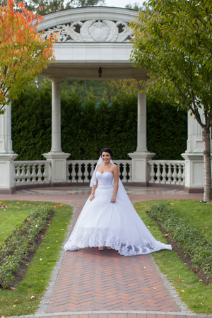 Bride on promenade in summer park posing on photoの写真素材