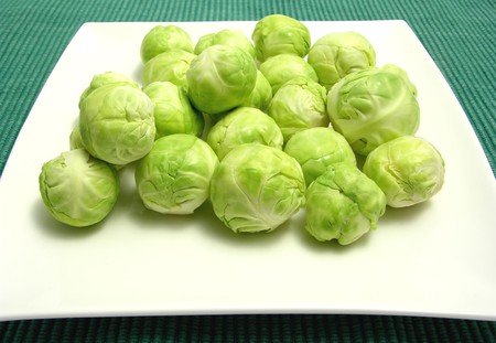 Brussels sprouts arranged on a white plate and green placematの写真素材