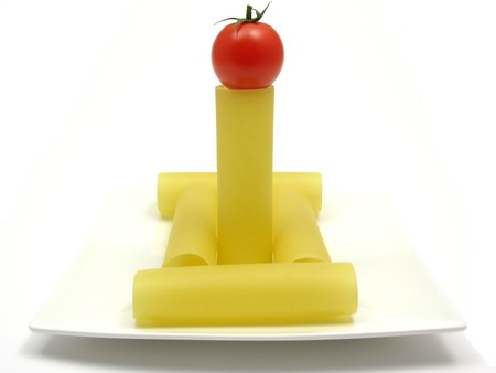 Several unboiled canneloni arranged on a white plate with tomatoの写真素材