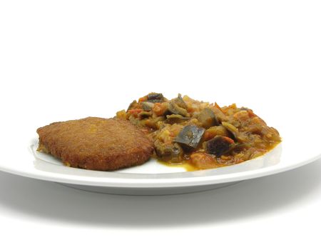 Breaded bean curd cutlet with fried vegetable on a white plateの写真素材