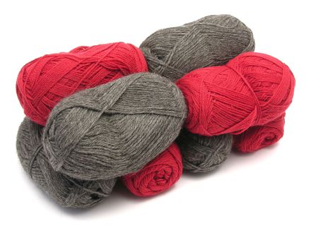 Gray and red new wool lying upon another on white backgroundの写真素材