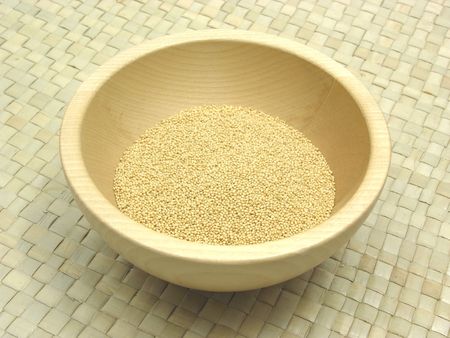 Wooden bowl with amaranth on rattan underlayの写真素材