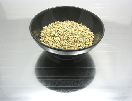 Black bowl of chinaware with buckwheat on reflecting surfaceの写真素材