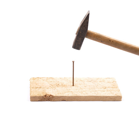 Hammer with nail and boardの写真素材