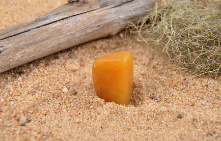 Orange calcite on beach sandの写真素材