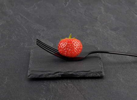 Strawberry on fork and shale の写真素材