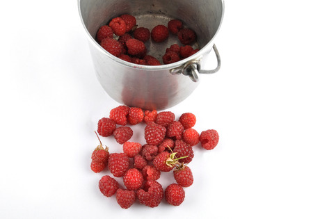 Red raspberries with tin bucket on white