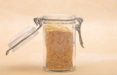 Wheat germs in open jar on brown backgroundの写真素材
